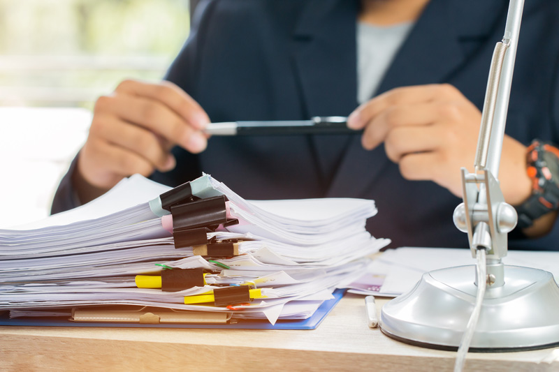 An-Investigative-analyst-with-paperwork-on-a-desk An Investigative analyst with paperwork on a desk