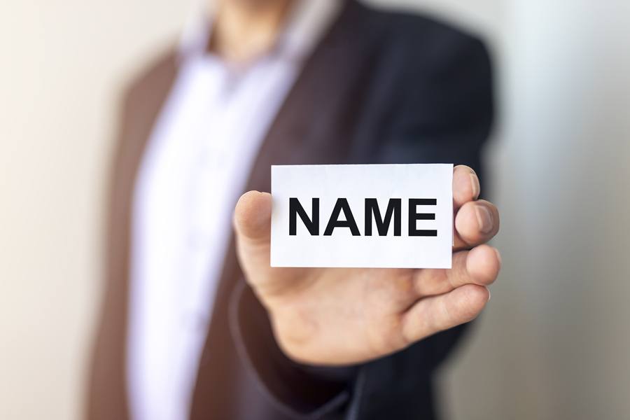 A-businessman-holding-up-a-sign-with-the-word-Name-on-it A businessman holding up a sign with the word Name on it