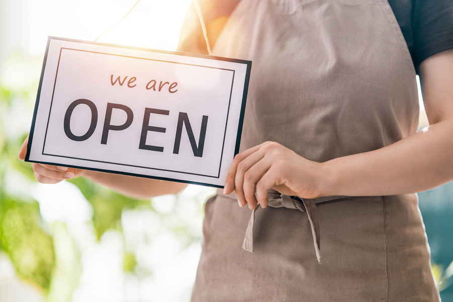 Small-business-owner-holding-a-We-are-open-sign Small-business-owner-holding-a-We-are-open-sign